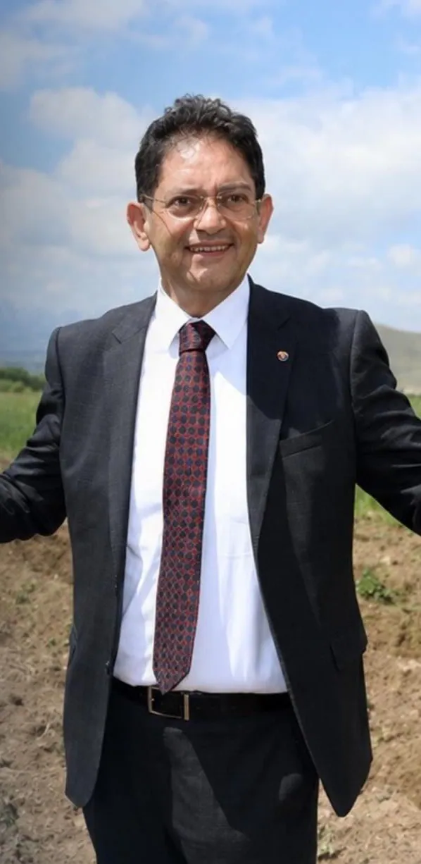 Hakan Oral tarlada, gökyüzünün altında gülümserken